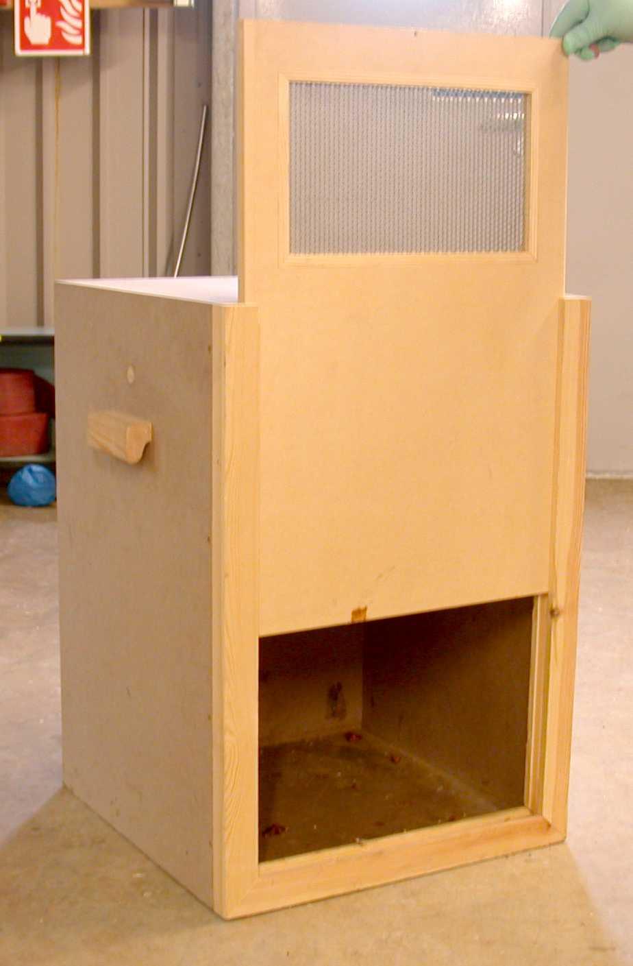 A wooden transport box with a sliding opening that can be closed once a macaque enters