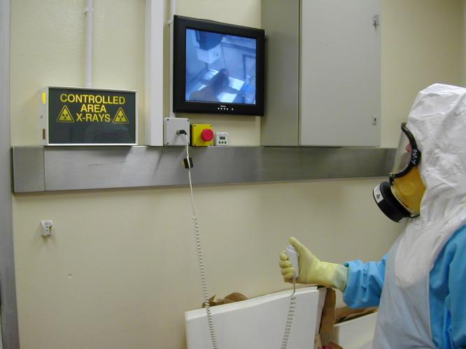 A technician takes an X-ray under containment