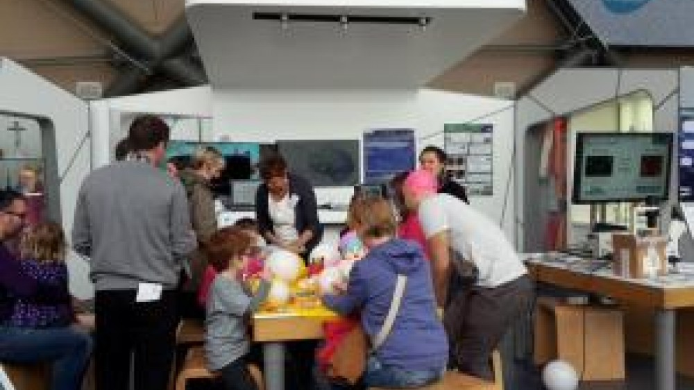 Children and adults around a table partaking in the learning about the 3Rs science fun for all ages