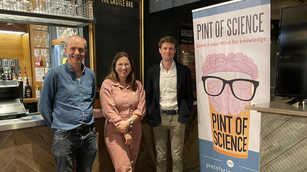 Dr Frank McCaughan and two other speakers stand by a Pint of Science banner