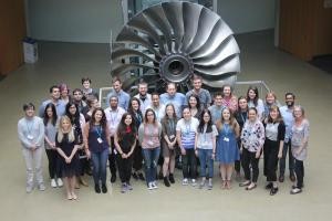 Students standing in front of a large turbine