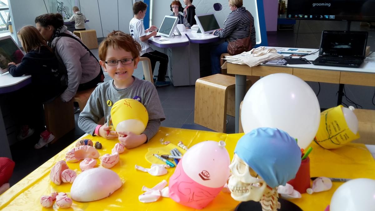 A child drawing a brain on a swimming cap at the learning about the 3Rs: science fun for all ages engagement 
