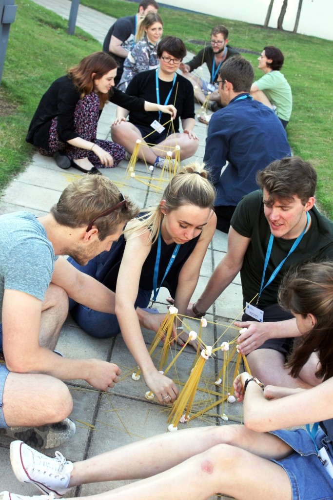A group of students sitting down on a path conducting an experiment 