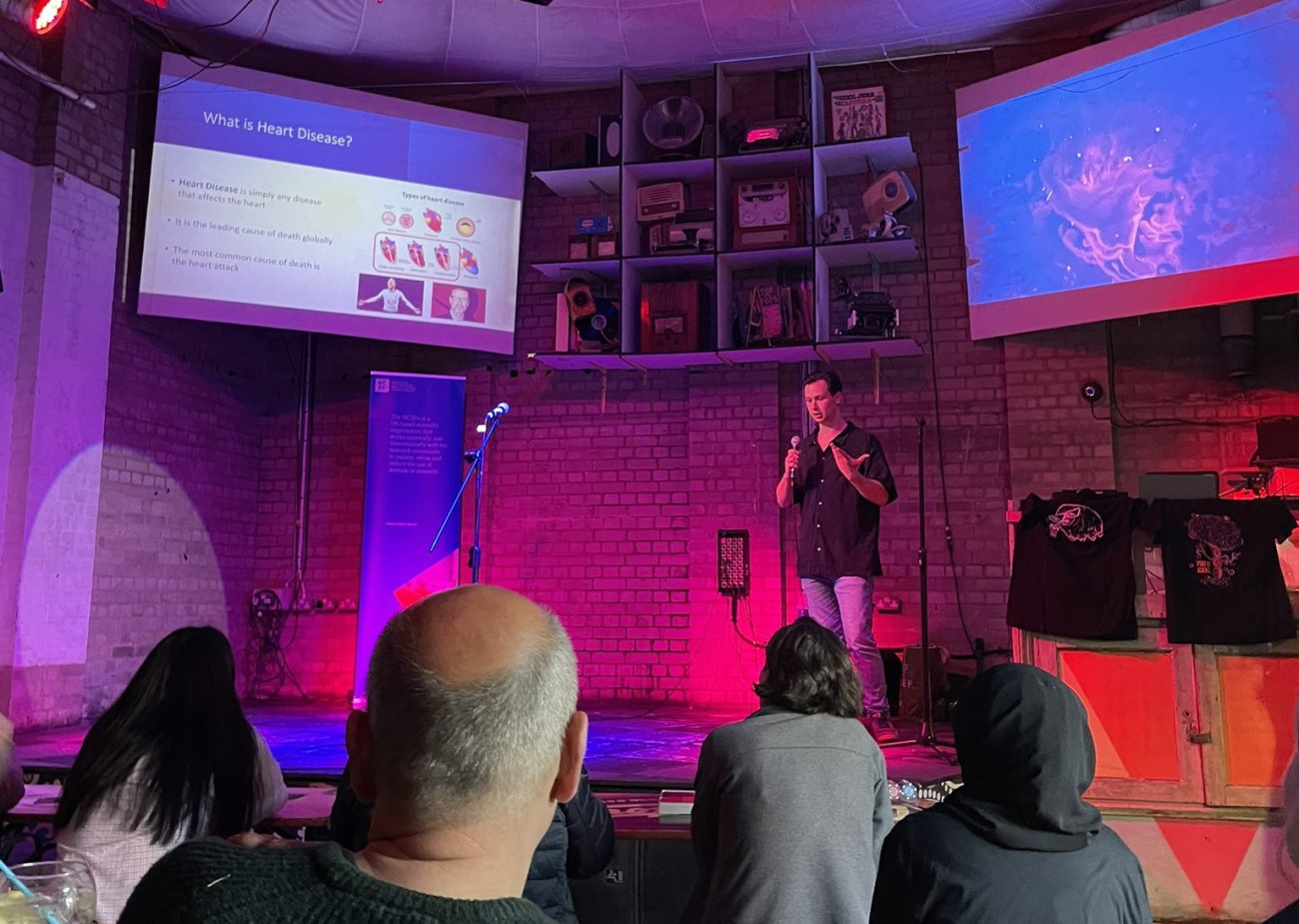 A scientist on stage giving a talk at a public engagement event.