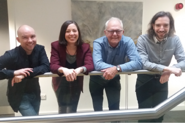 Professor Peter Diggle with four colleagues standing with hands over a handrail 