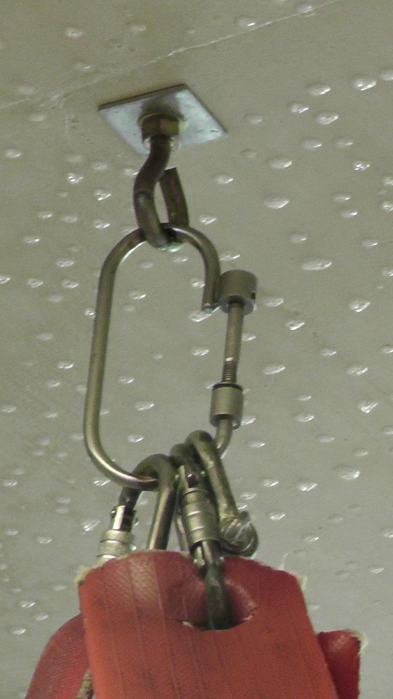 An example of fire hose attached to a ceiling in an indoor enclosure by carabiners on a ceiling hook 