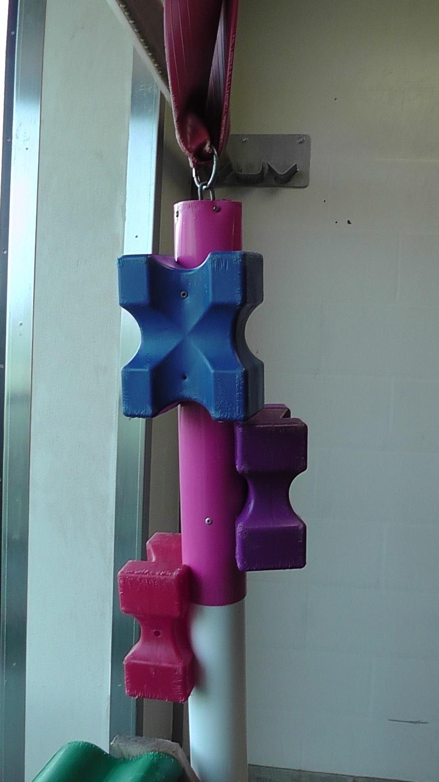 PVC pipe with plastic blocks attached suspended from a fire hose for structural enrichment
